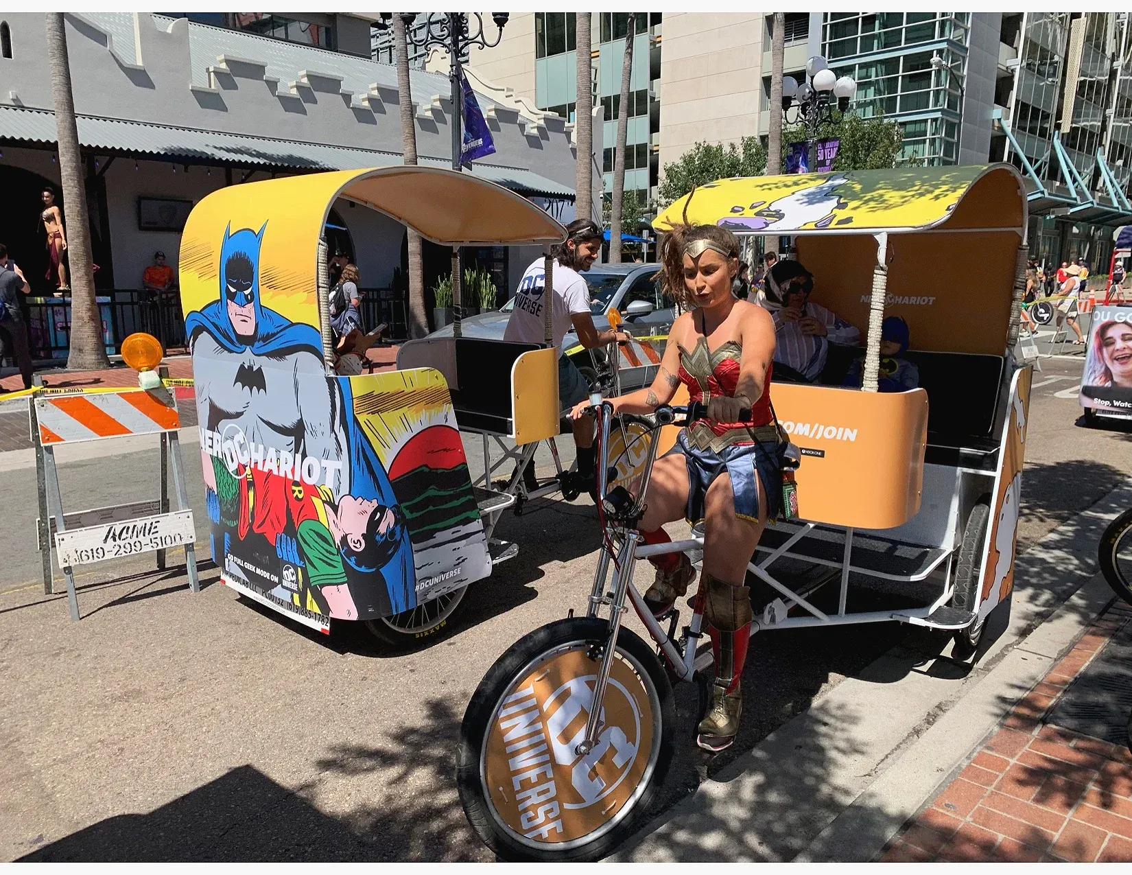 DC Comics Batman and Wonder Woman cosplay driver on branded pedicab at Comic-Con