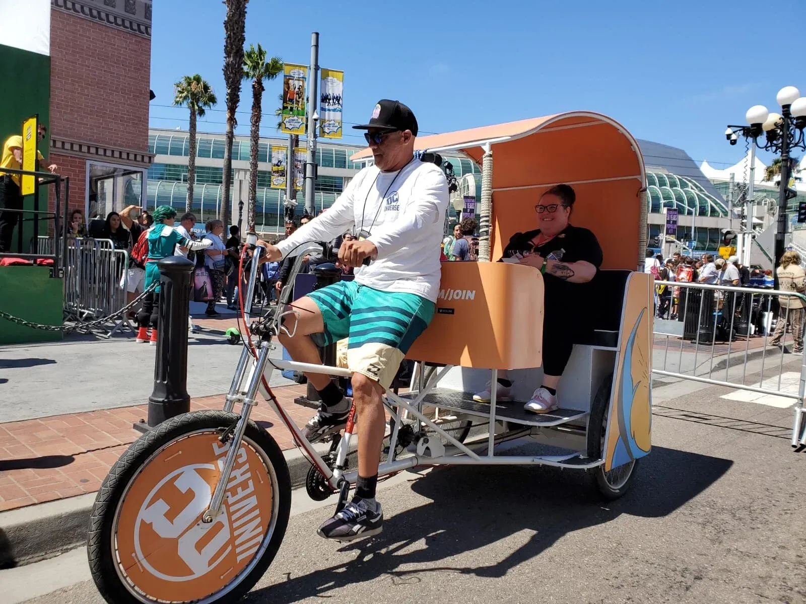 DC Universe branded pedicab rider at convention center during Comic-Con