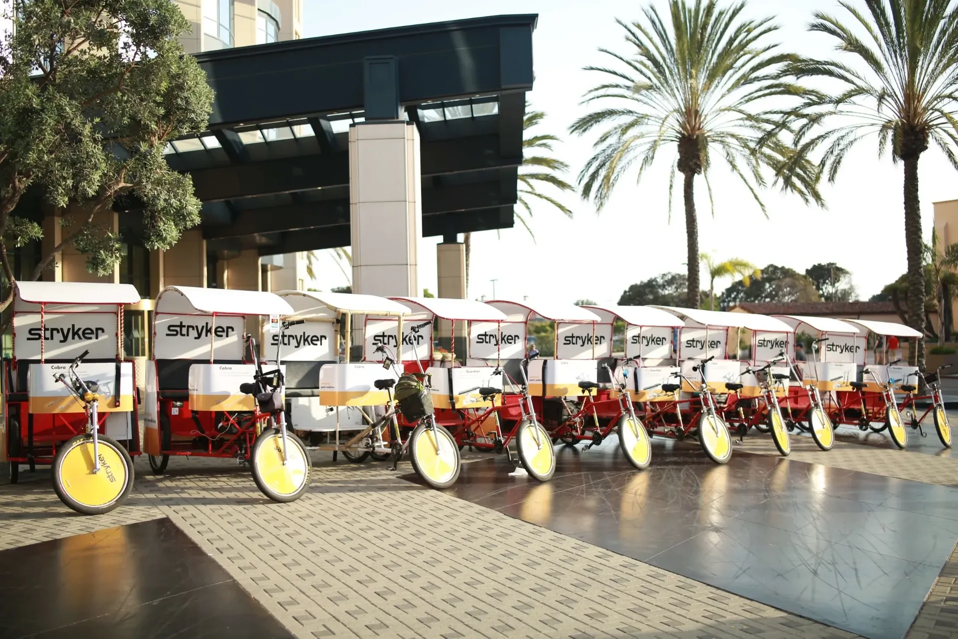 Stryker branded pedicab fleet lined up at hotel in San Diego