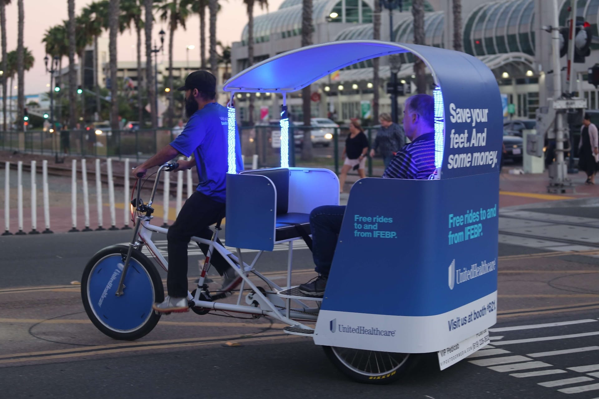 UnitedHealthcare pedicab with LED lights riding at night near Convention Center
